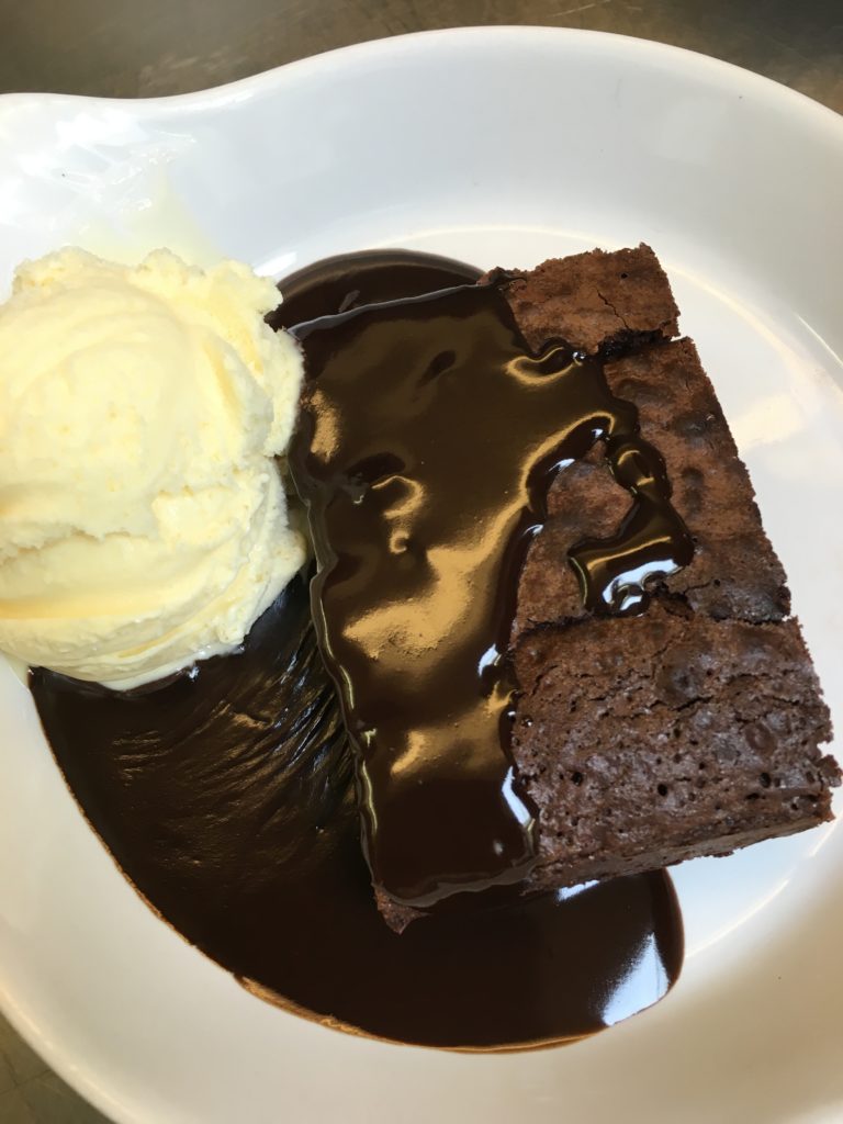 Homemade chocolate brownie with vanilla ice cream and rich chocolate sauce
